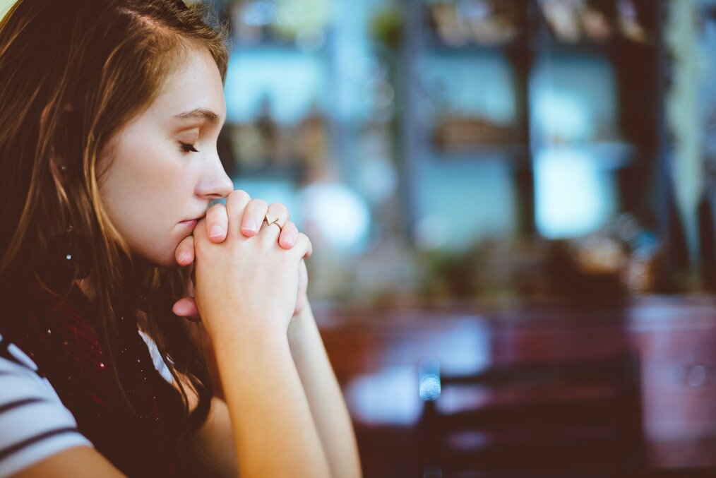 Photo by Ben White on Unsplash Woman with eyes closed, resting chin on hands.