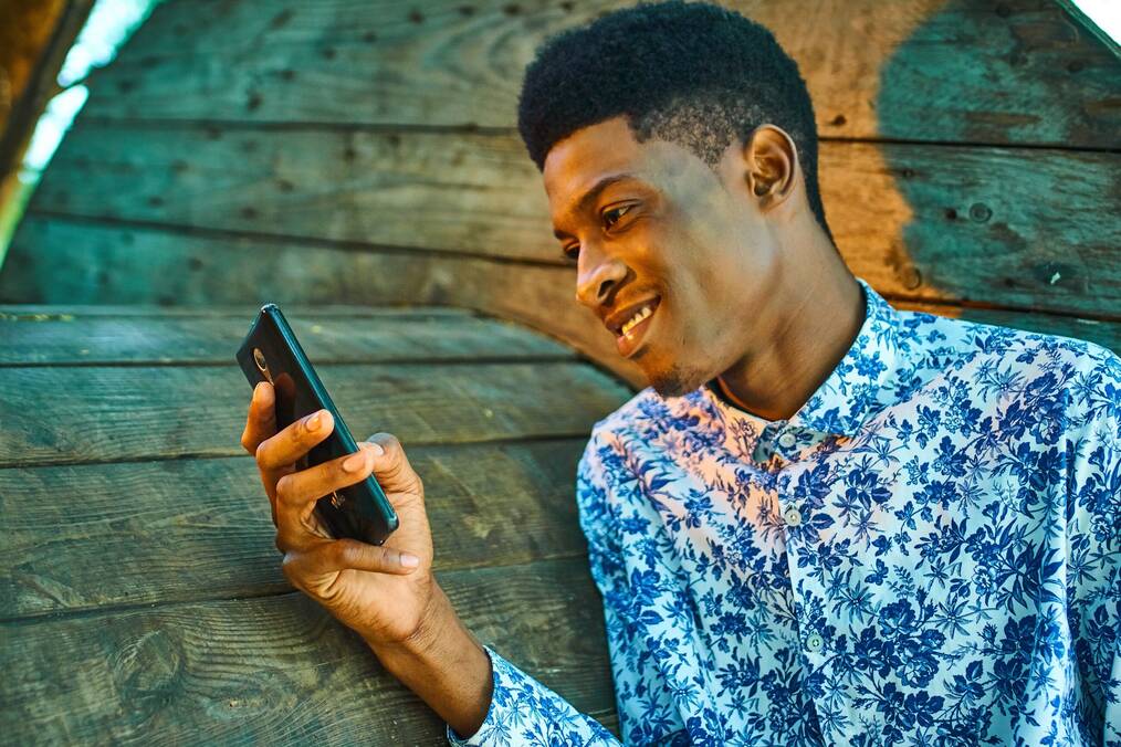 Man looking at cell phone and smiling.