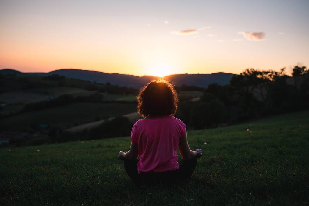 Woman meditating in a field.