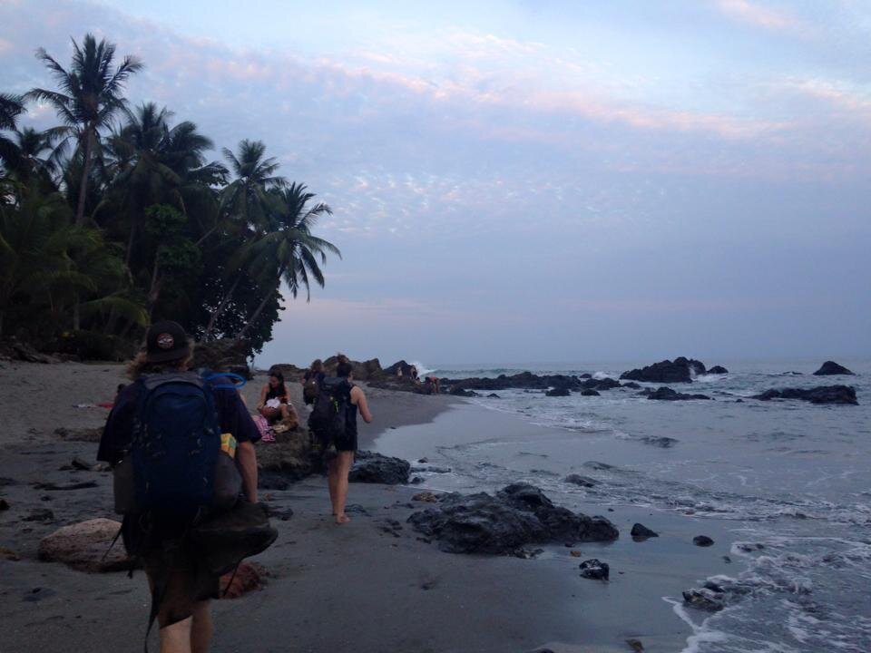 San Ramon by Robyn E. Several people hiking on a beach.