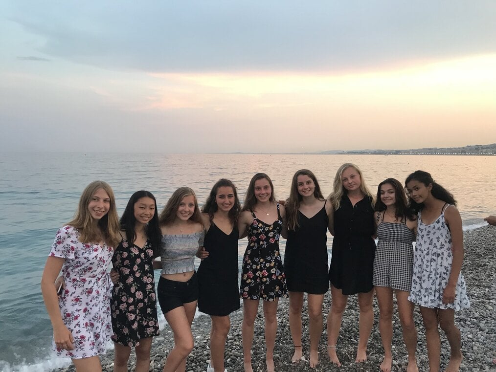 MEI by Kayla A group of girls smiling on a beach.