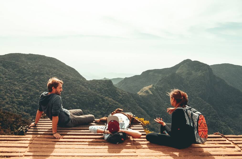 Three friends sitting in the mountains.