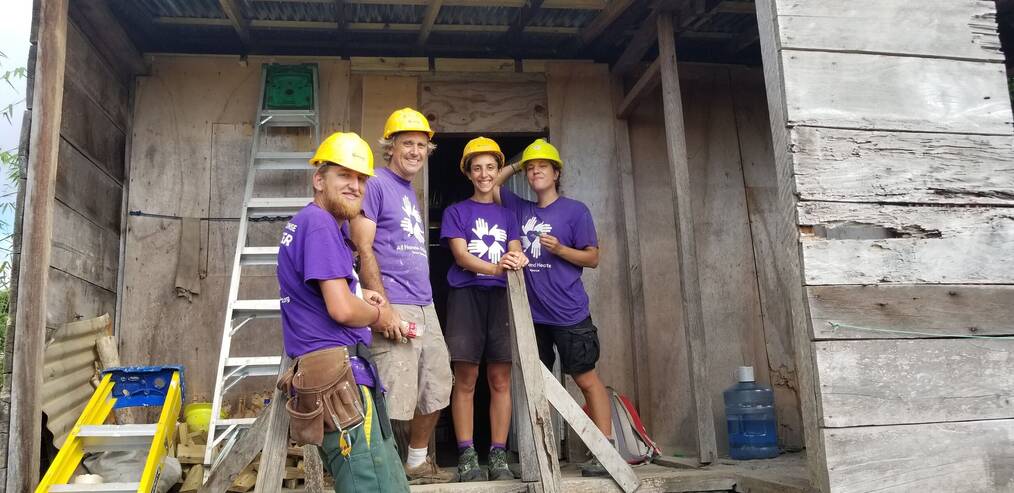 Group of smiling volunteers doing construction