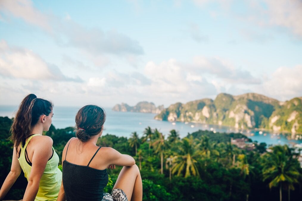 Two people sitting on a cliff in Thailand