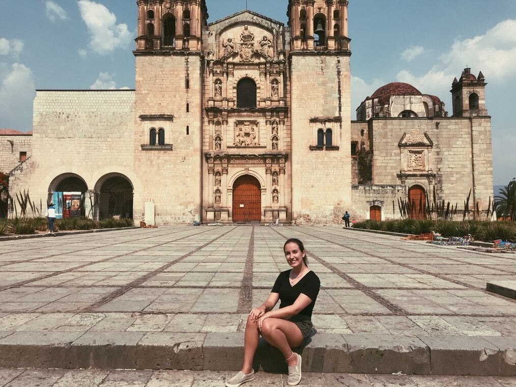 Person sitting in front of historical building