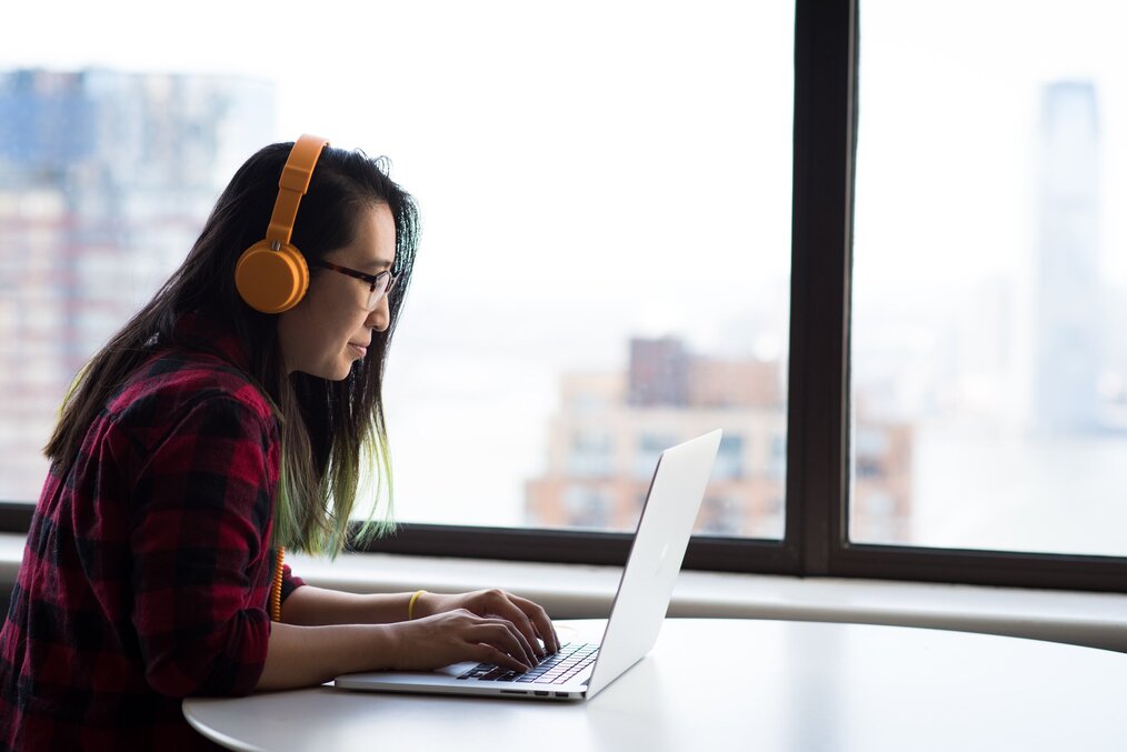 Person with headphones on while using their computer