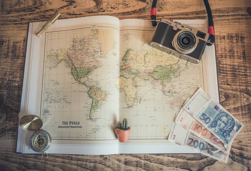 Map, money, and camera on a desk