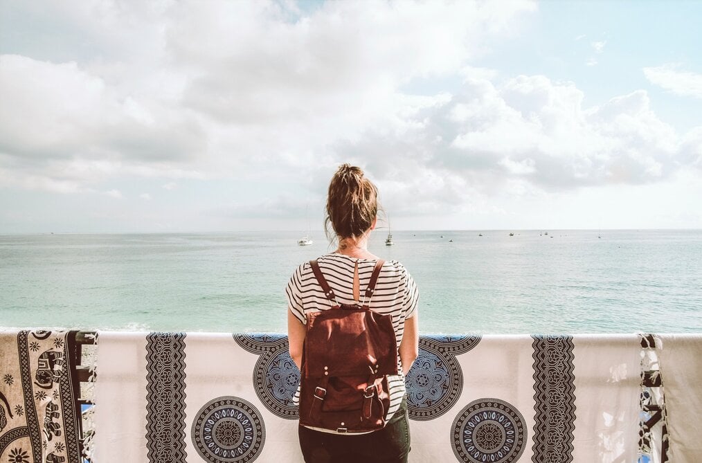 Person looking at water with backpack on