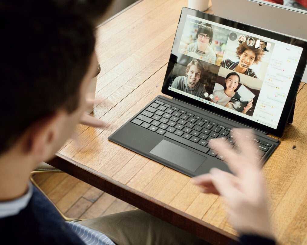 Person using laptop to video call with friends