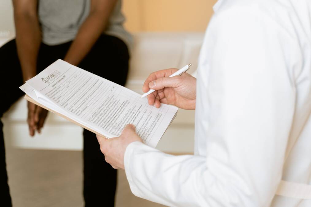 Doctor holding document and talking to patient 