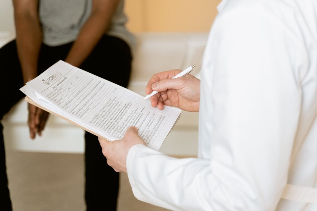 Doctor holding document and talking to patient