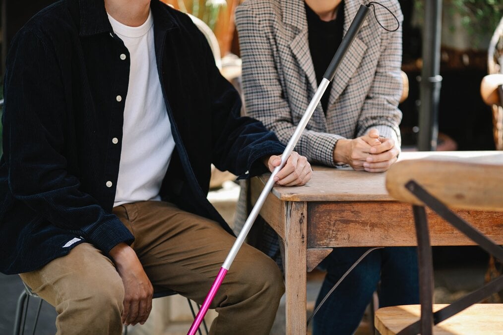 Person holding mobility cane for blind and visual impairment