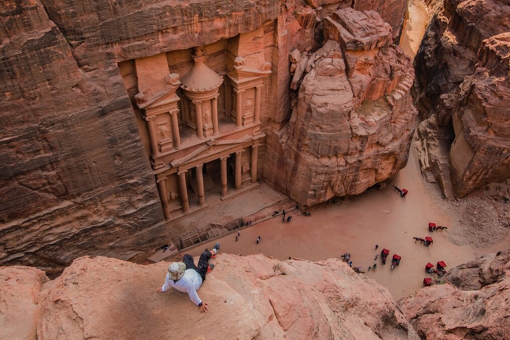 A man sitting on a cliff in Petra, Jordan.