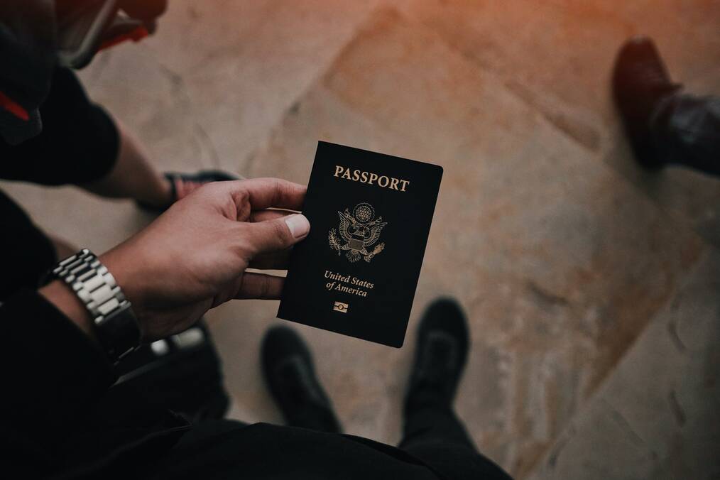 A hand holding a US passport.