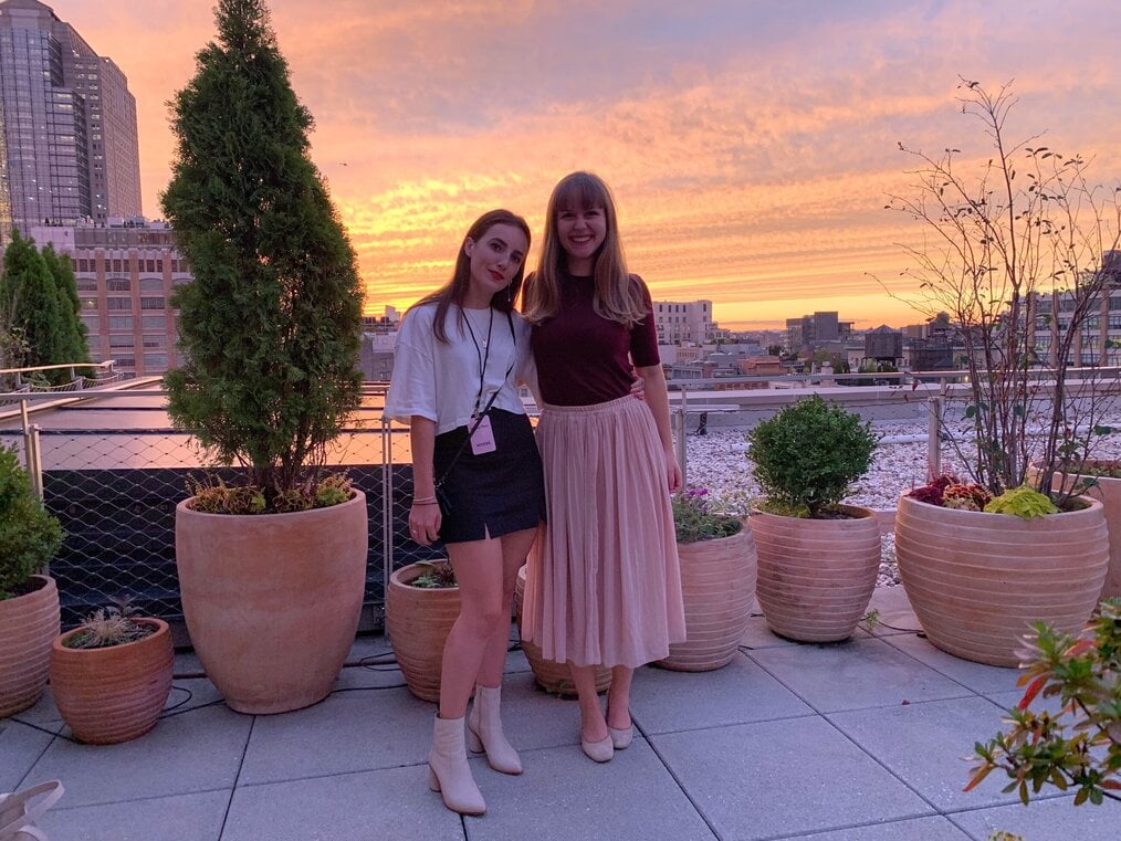 Two interns standing in front of pink and orange sunset