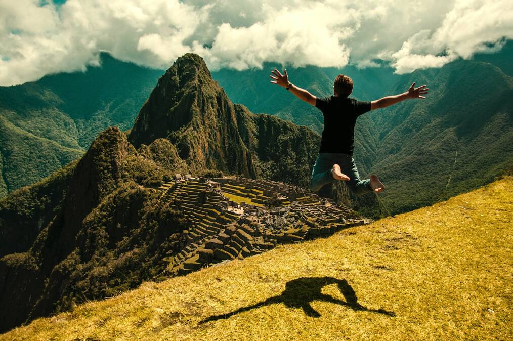 Man jumping in the air by Machu Picchu.