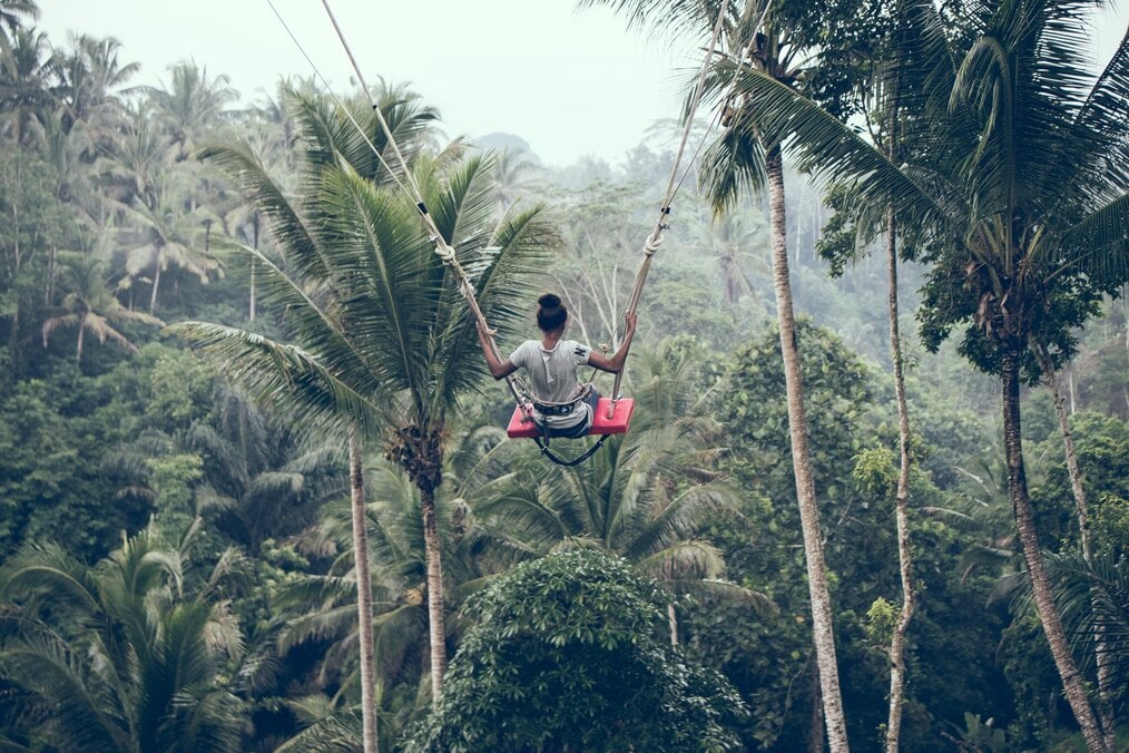 Person on swing in trees in Bali