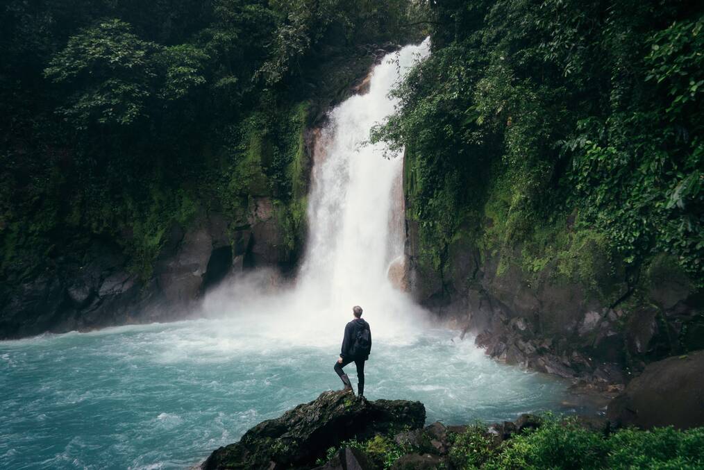 Man standing in front of a waterfall.