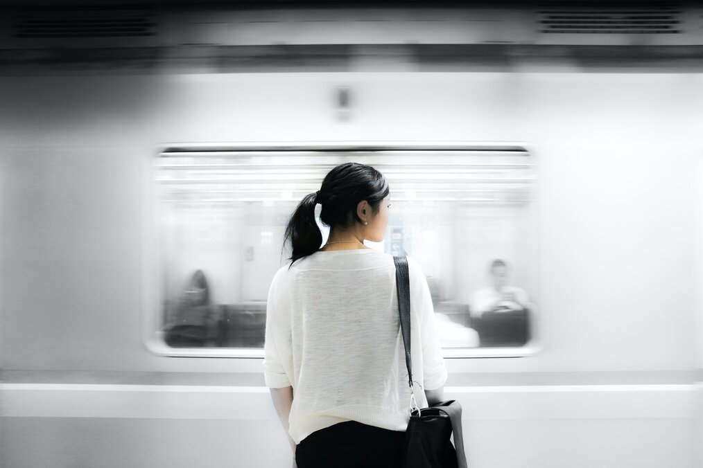 Person standing at train station, waiting for train