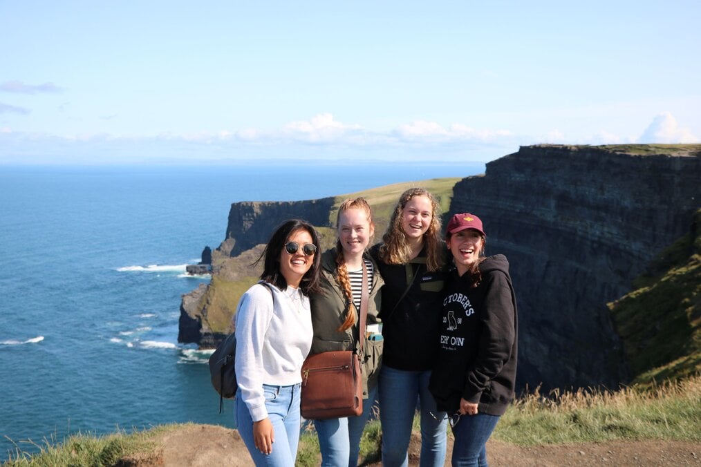 Four women standing by a cliff in Ireland.