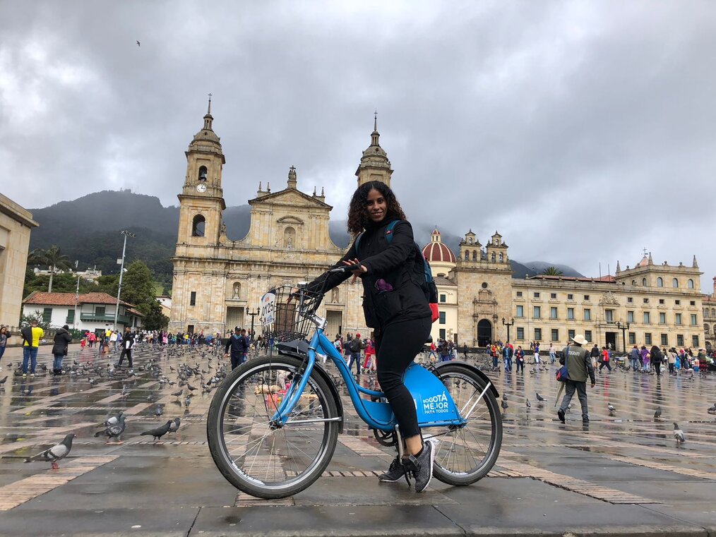 Abigail, Red Tree Study Colombia Alum A student riding a bike in a public square in Colombia