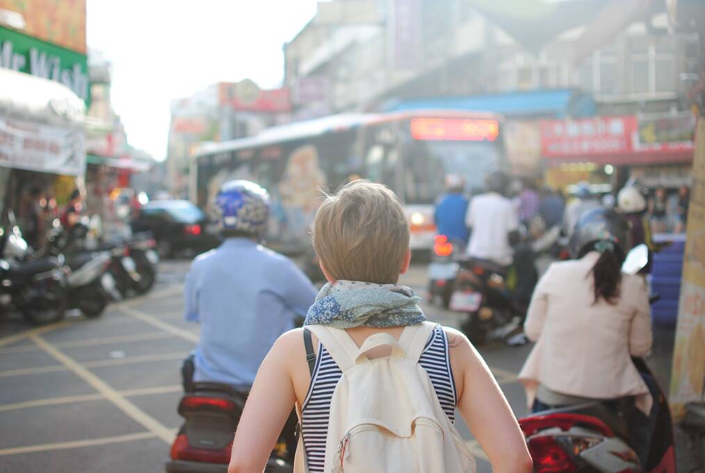 Person wearing a backpack walking through busy city