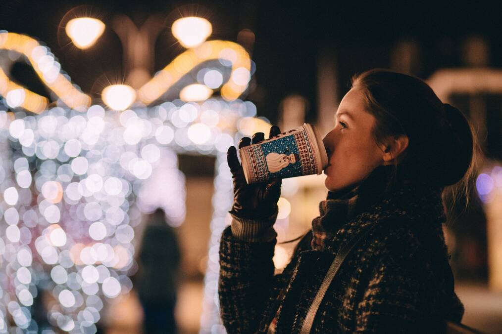 Student drinks mulled wine at winter market