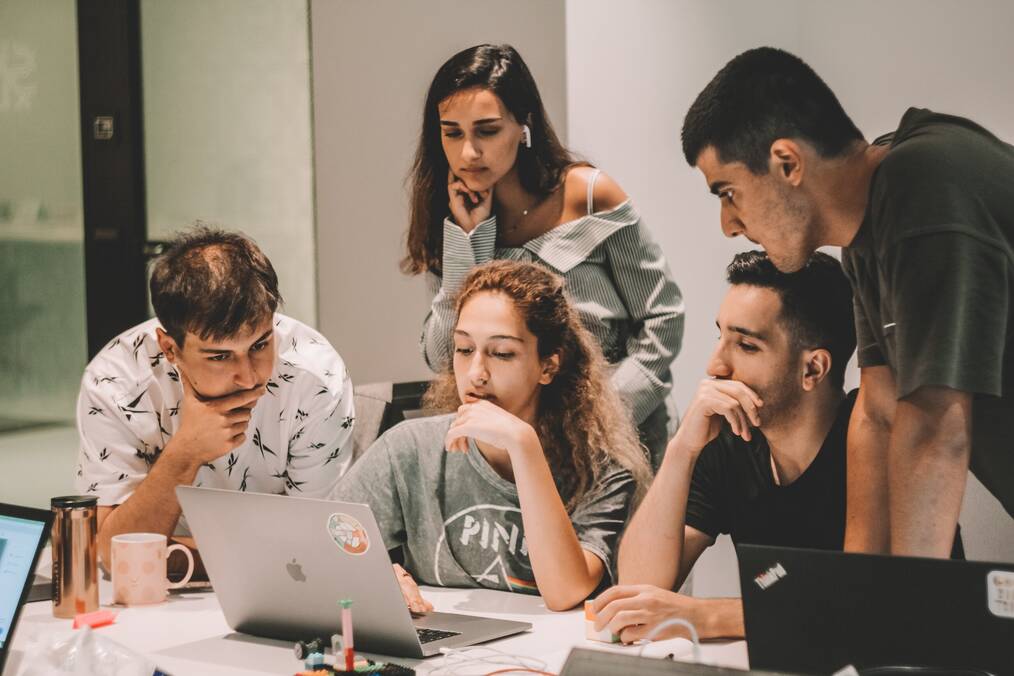 A group of people looking at a computer.