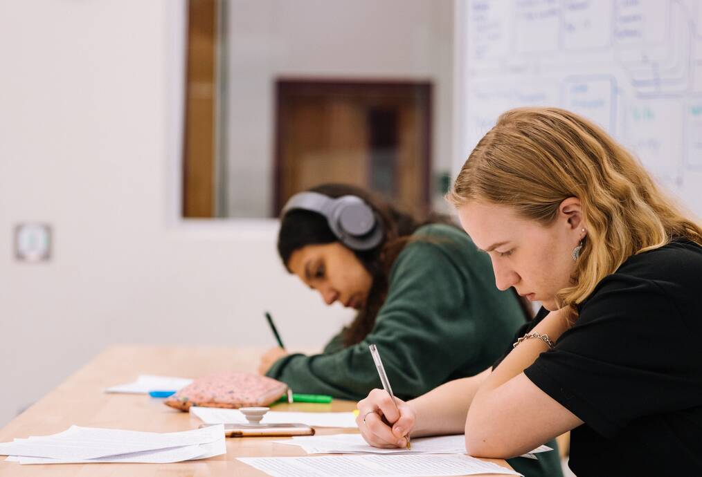 Two students writing.
