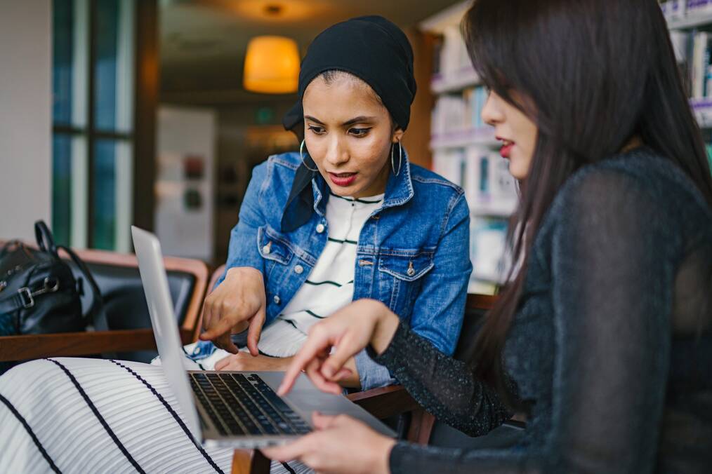 Two women looking at a laptop screen.