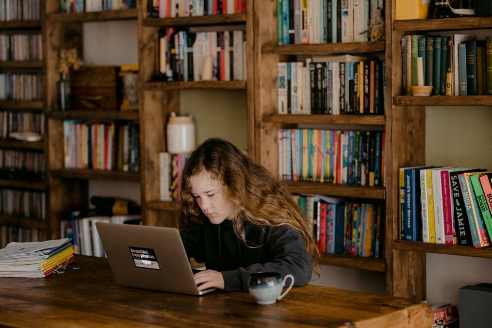 Photo by Annie Spratt on Unsplash Woman sitting at a desk working on a laptop.
