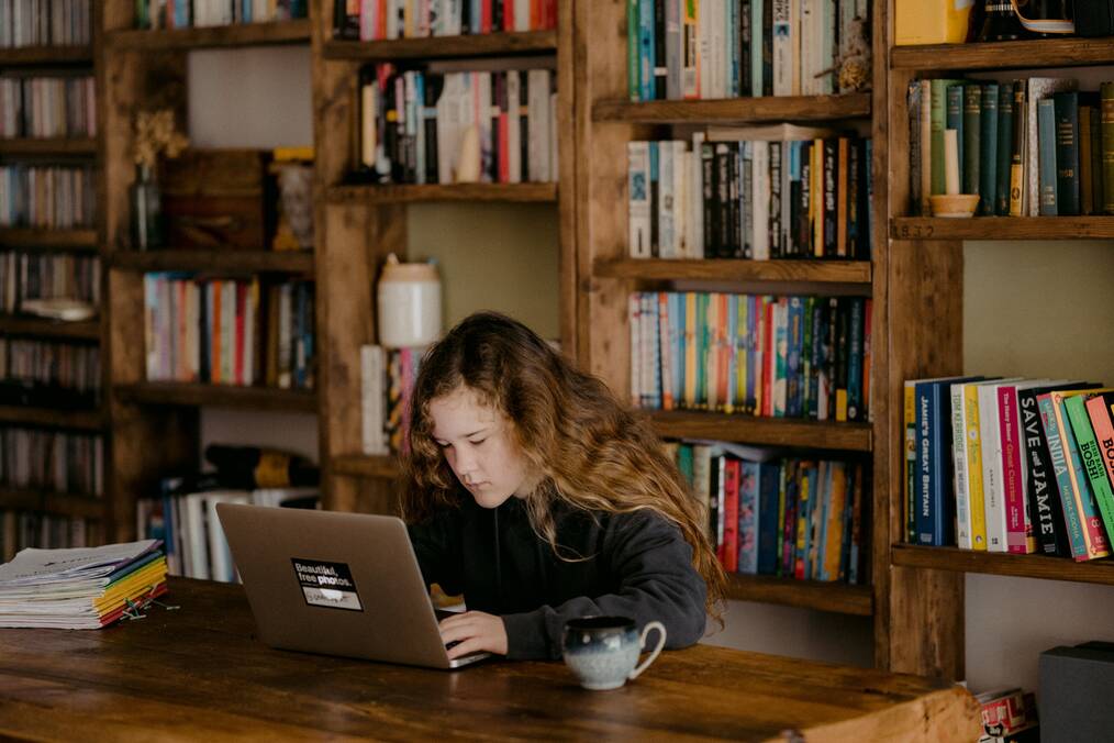 Woman sitting at a desk working on a laptop.