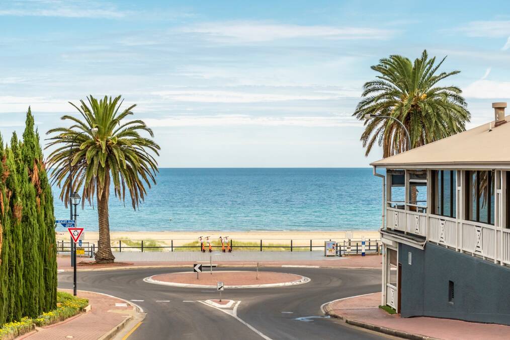 A street leading to a white sand beach in Australia.