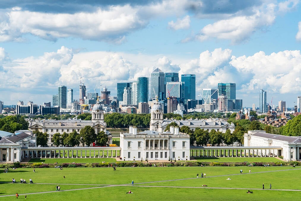 An old building sitting in front of a modern cityscape