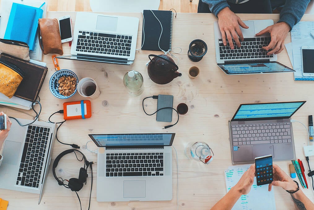 A Birdseye view of a table filled with computers and tech gear