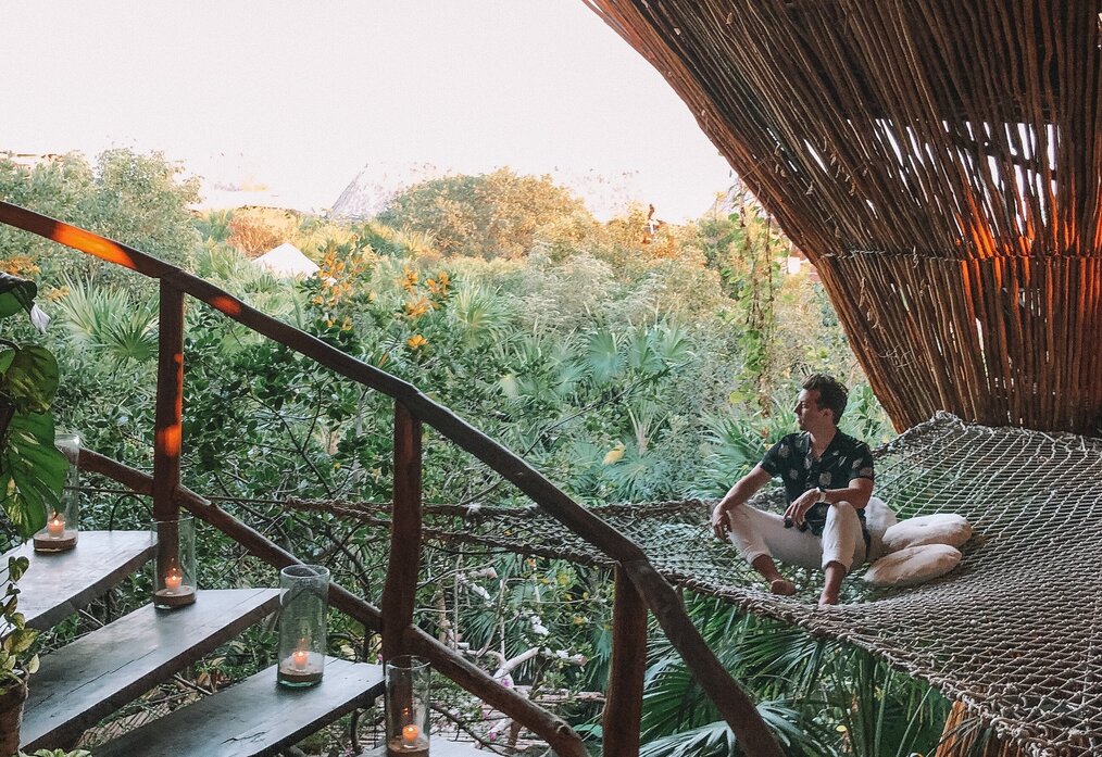 Image curtesy of Austin Distel, Unsplash A digital nomad sitting in a treehouse in bali