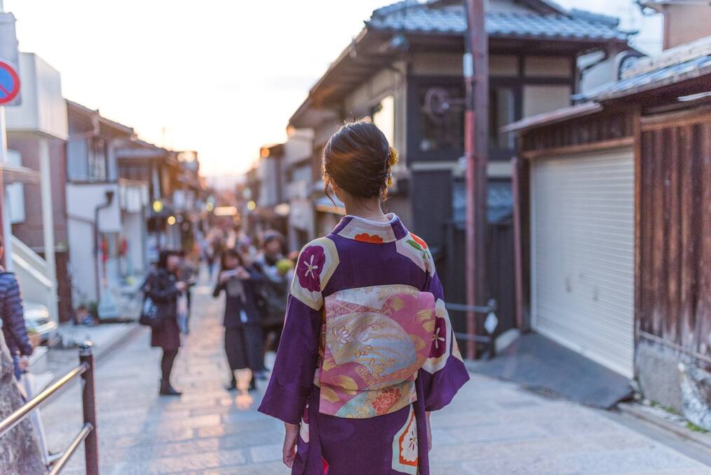 A women dressed in traditional gown walking down the street