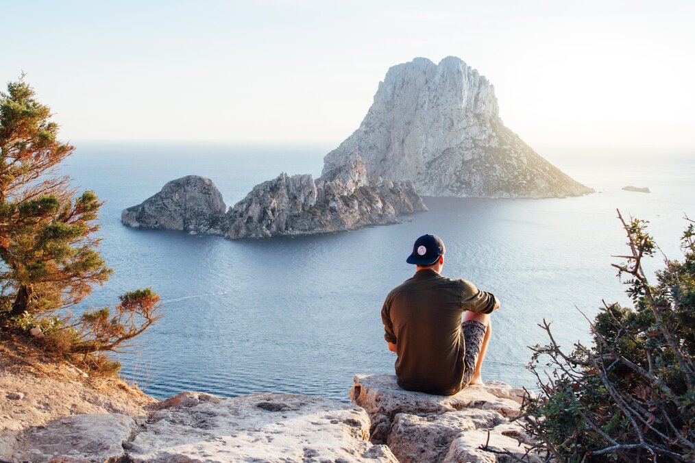 Image curtesy of Riccardo, Pexels A digital nomad sitting at a viewpoint looking at ocean