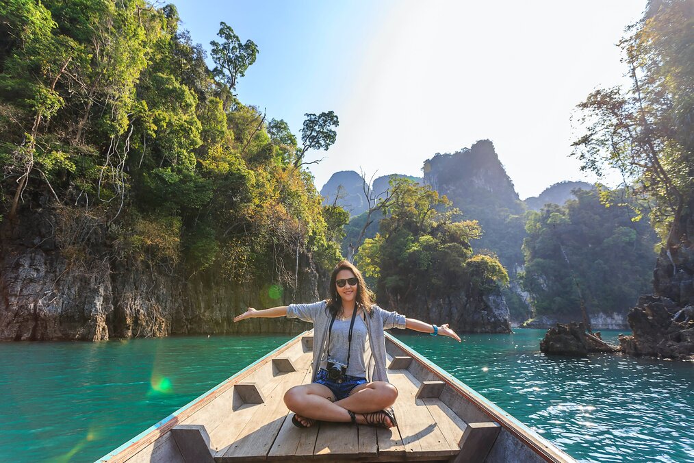 Image curtesy of Te Lansfix, Unsplash A digital nomad sitting in a boat in Thailand