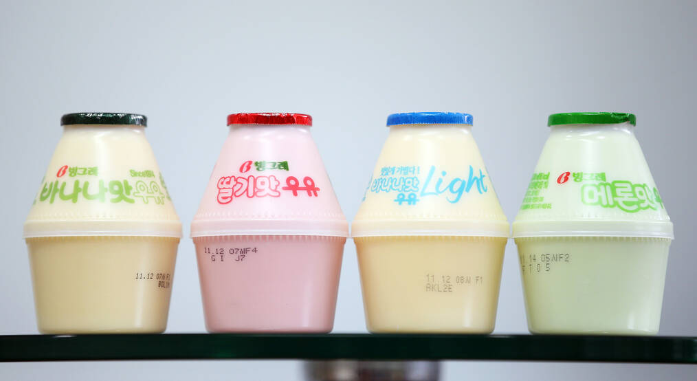 Four colored plastic bottles of Korean banana milk sit in a row.