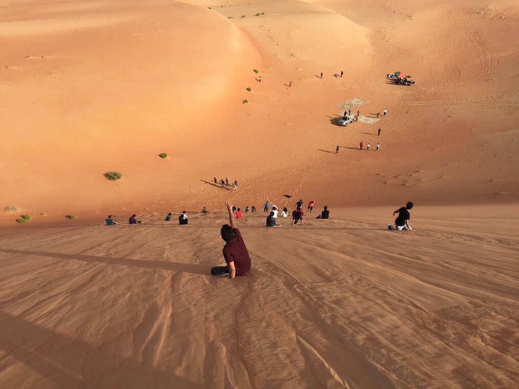Image curtesy of Ayush Jain, Unsplash Children sliding down a desert hill in Dubai