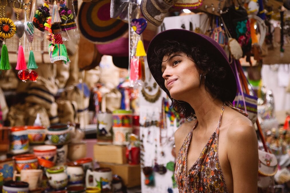 Photo by Los Muertos Crew on Pexels A woman smiling in a marketplace.