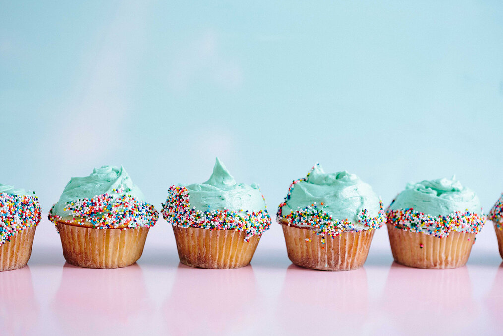 A line of cupcakes with blue frosting