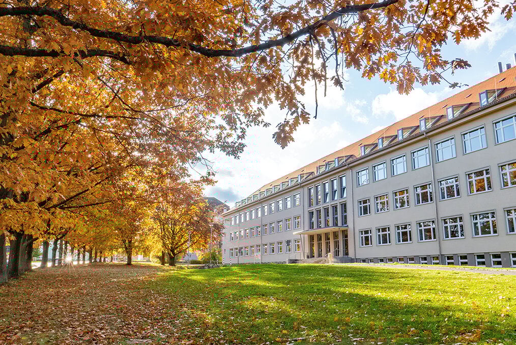 A grassy field with a university building in the background