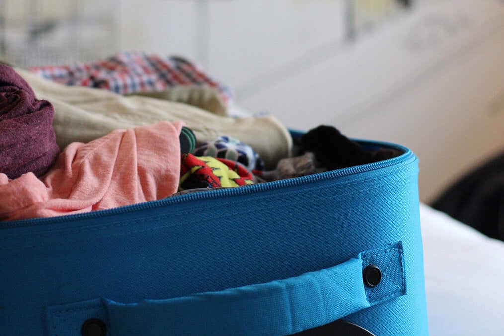 A blue suitcase with clothes in it