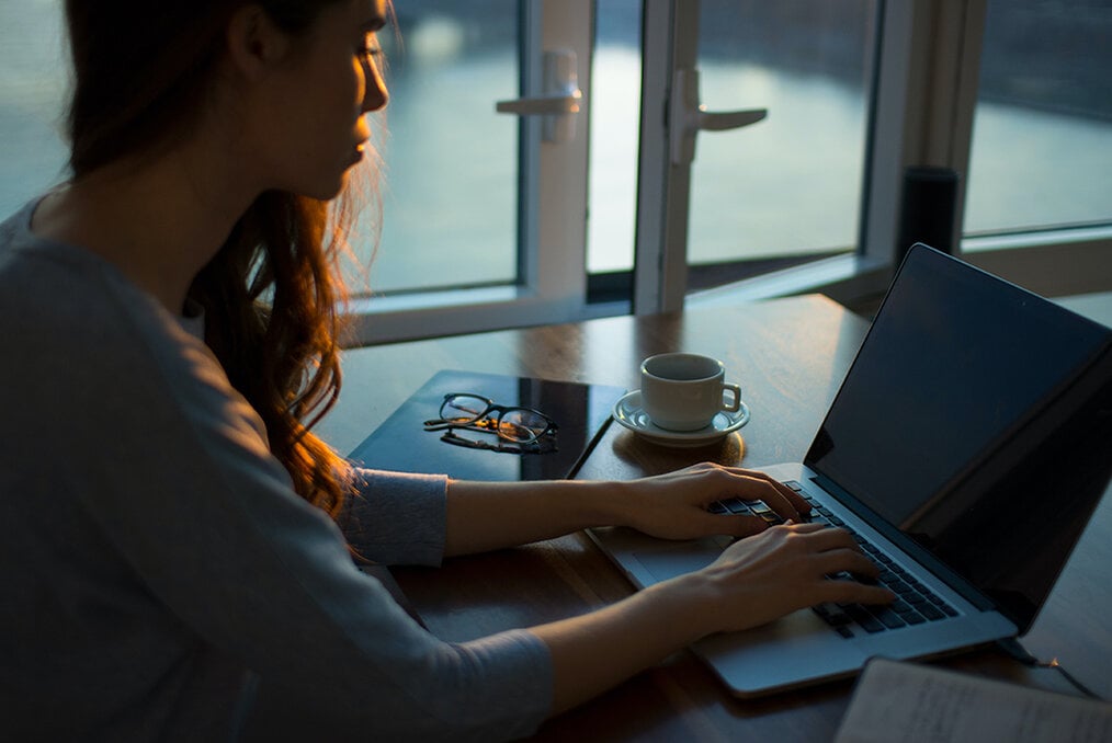 A person at a desk typing on a laptop