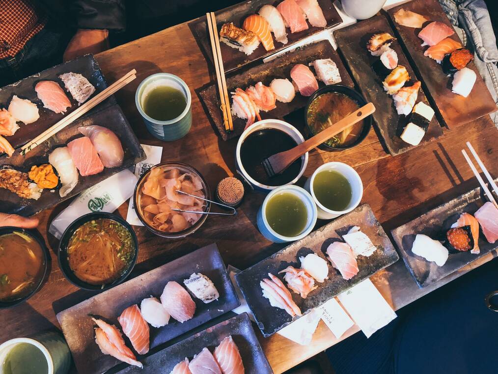 A table with many plates of sushi.