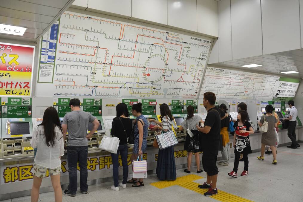 People buying metro tickets in Tokyo station.