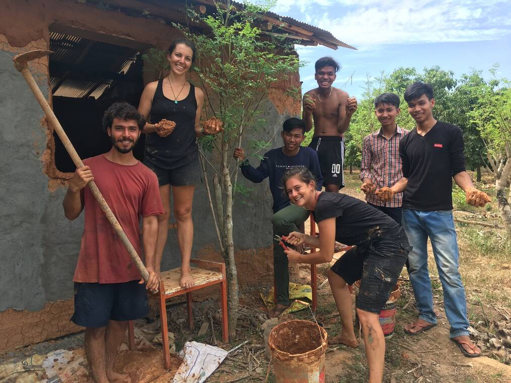 A volunteer group planting a tree and smiling.
