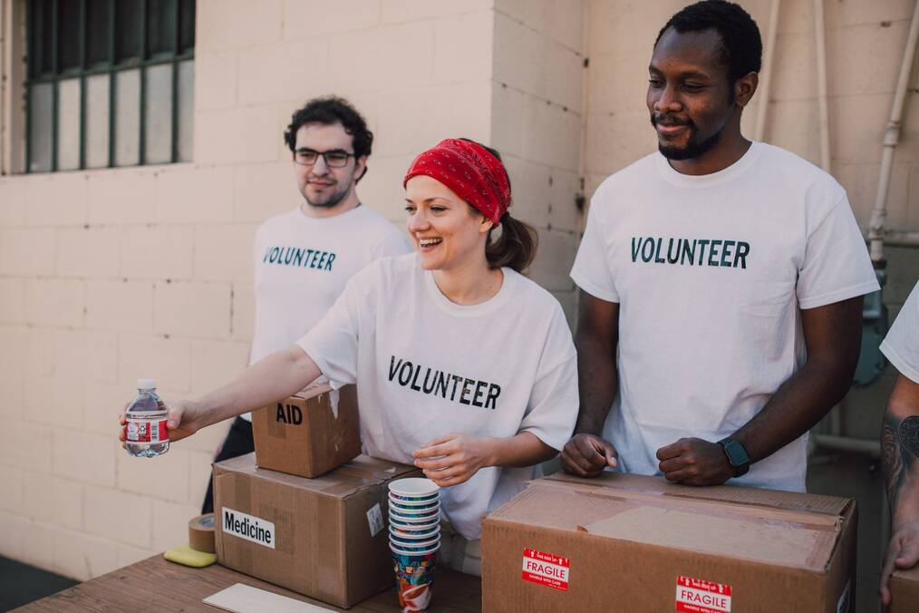 Three volunteers handing out supplies.